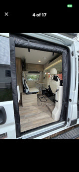 Step inside this modern **rv rental** camper van. Features wood-look flooring, seating, table, and overhead storage, offering a compact living space.