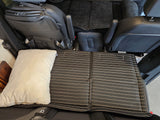 Custom sleeping setup in an RV rental, featuring a striped mattress pad and pillow for comfortable travel.