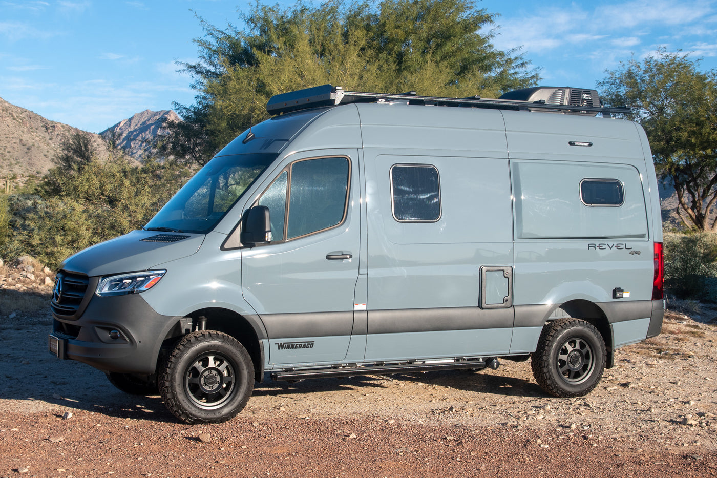 Explore the outdoors with this gray Winnebago Revel 4x4 camper van, perfect for an rv rental adventure.