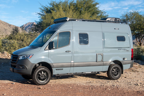Explore the outdoors with this gray Winnebago Revel 4x4 camper van, perfect for an rv rental adventure.