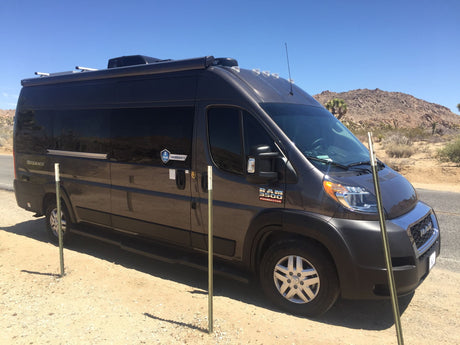 Dark grey Ram ProMaster camper van. Ideal for an RV rental adventure through desert landscapes.