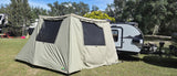 Spacious tent awning attached to an RV rental travel trailer at a sunny campsite, ready for outdoor adventures.