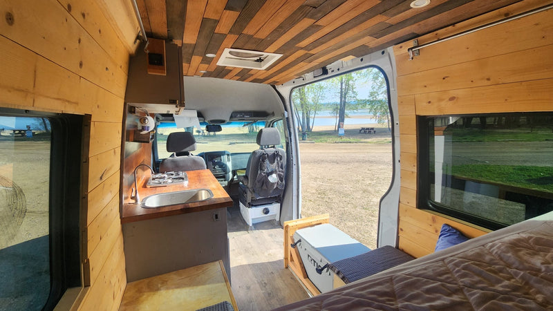  ready for travel.|RV rental: Spacious wood-paneled camper van interior with kitchenette — photo 2
