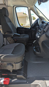 RV rental van's front cabin. Features swiveling seats, dashboard, cup holders, and a fire extinguisher for safety.