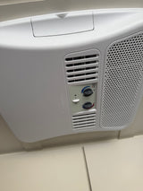 White Dometic RV rental air conditioner on ceiling with control panel, showing fan, temperature, and optional heat.