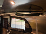 Bright ceiling light illuminates the polished interior of this RV rental, featuring overhead storage, a window, and durable walls.