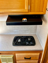 RV rental kitchen with a black two-burner stovetop, range hood with "ROVENTURE" logo, and wood cabinets.