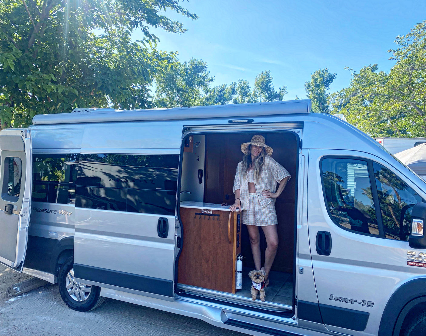 Woman & dog in their Pleasure-Way camper van, perfect for an RV rental adventure.
