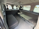 RV rental's custom camper van interior: comfortable bench seating, convertible sleeping area, and practical under-seat storage.
