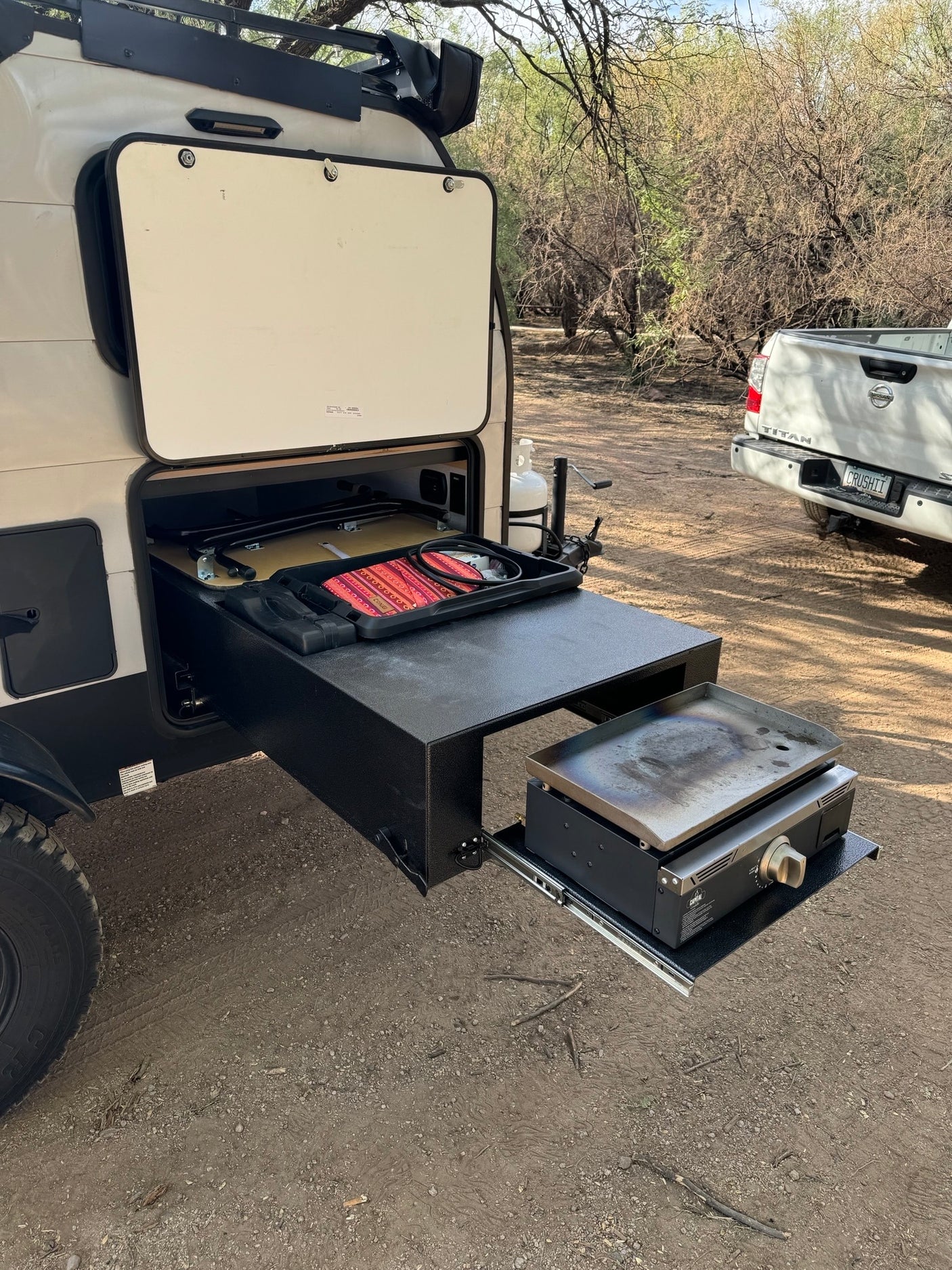 RV rental with handy pull-out outdoor kitchen setup featuring a griddle, perfect for easy campsite cooking.
