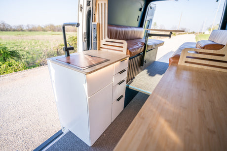 Stylish camper van kitchen and seating area with a view, perfect for an RV rental escape.