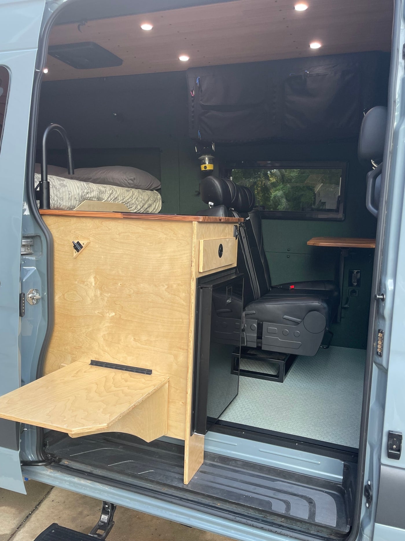  is ready for your next RV rental adventure.|Scenic RV rental campsite: A grey camper van with extended awning — photo 3