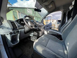 View inside an RV rental van, showing the simple gray interior with dashboard, steering wheel, and front seats.