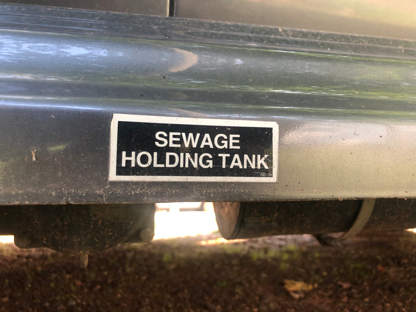 A clear label on an RV rental identifying the 'SEWAGE HOLDING TANK' under the vehicle, vital for waste management.