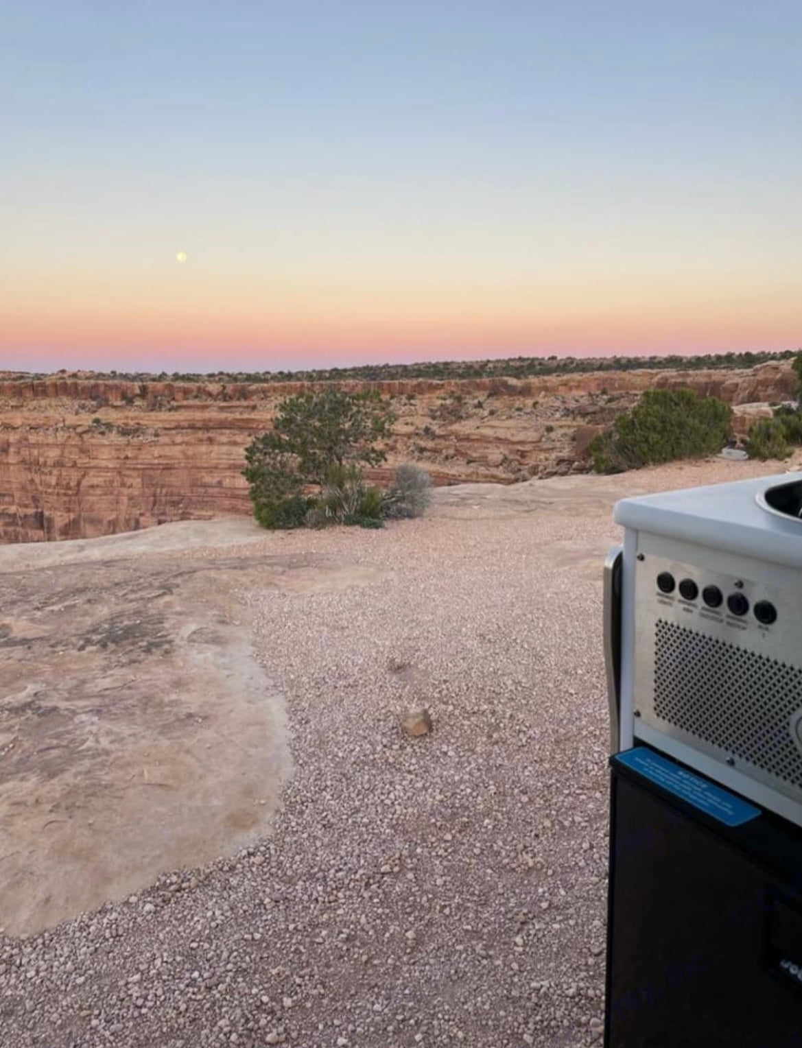Stunning desert canyon vista at sunset with a moon, seen from an RV rental. Perfect for outdoor adventure travel.