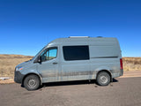 Gray Mercedes-Benz Sprinter camper van, perfect for your next RV rental adventure, parked under a clear blue sky.