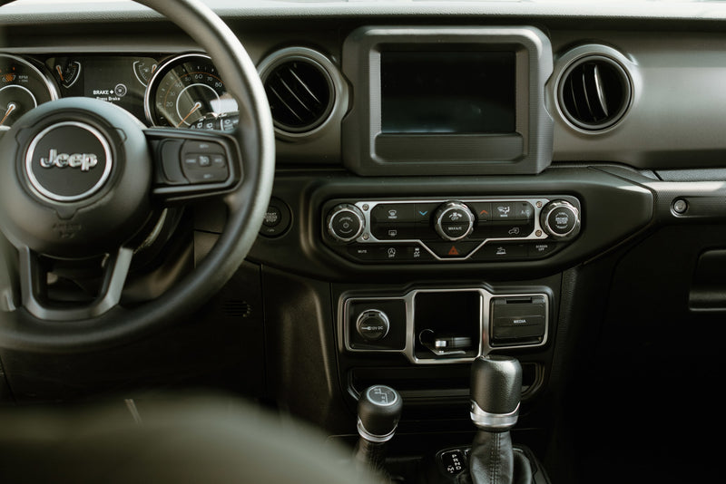 Jeep interior showing dashboard, steering wheel, screen, and shifters. Perfect for exploring, like a rugged rv rental adventure. — photo 8