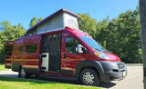 Red pop-top camper van rv rental with doors open, parked by trees under a blue sky, ready for adventure.