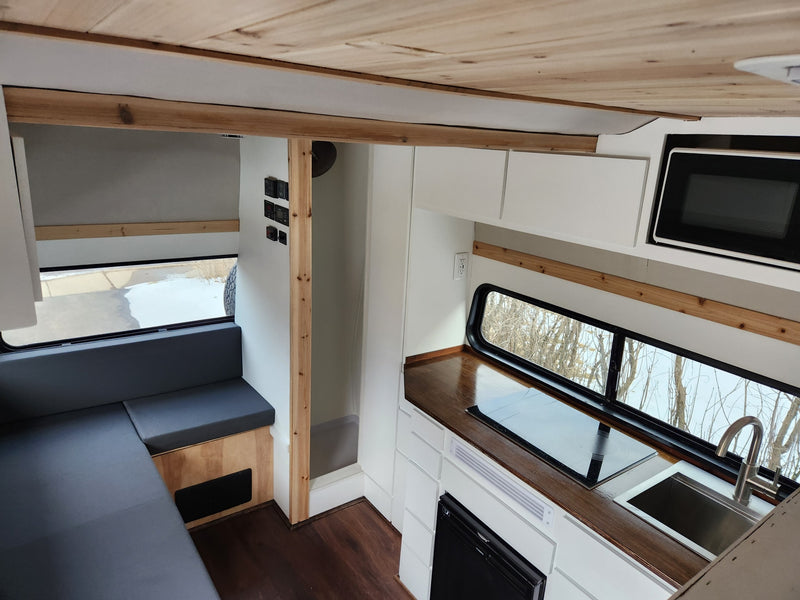  parked on a driveway.|RV rental interior featuring a modern kitchen with sink — photo 2