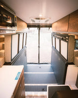 Explore this practical rv rental interior with kitchen, modular sleeping/storage, and rear entry for versatile mobile living.