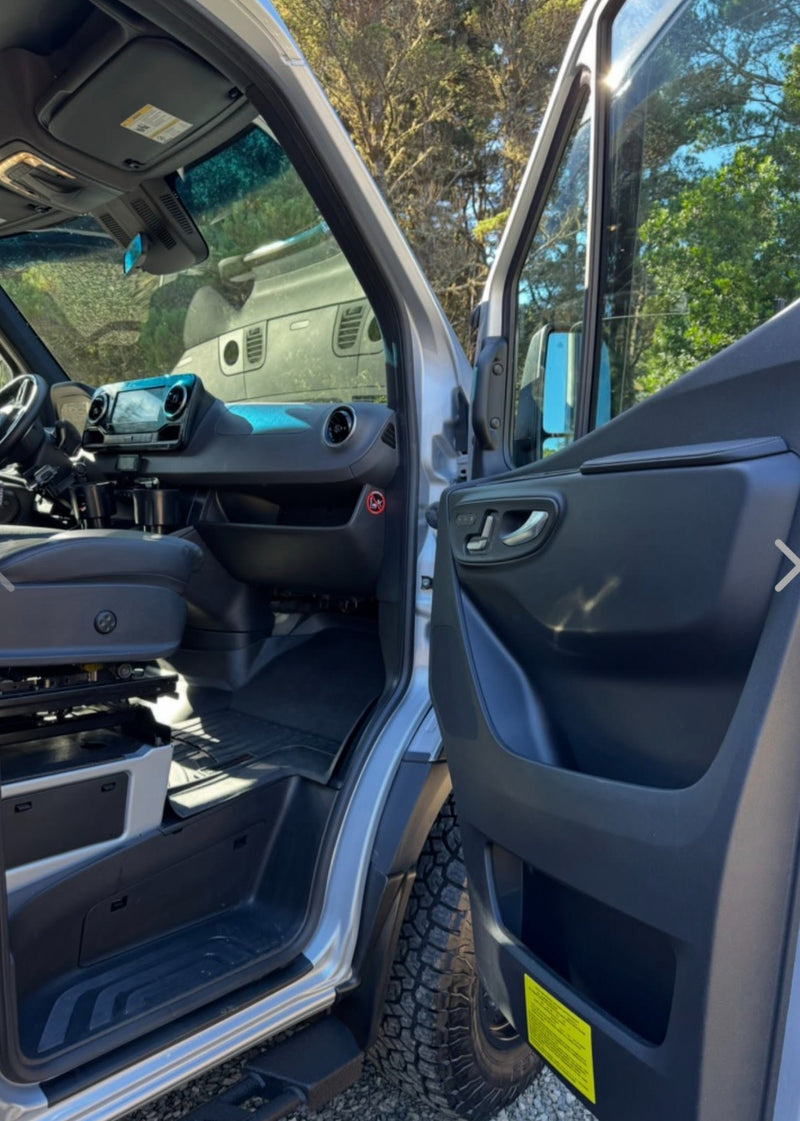  a dog on a leash nearby.|Silver Mercedes-Benz Sprinter camper van parked among tall trees. Ready for your next RV rental adventure!|Experience freedom with this RV rental camper van! Rear view showing open doors — photo 3
