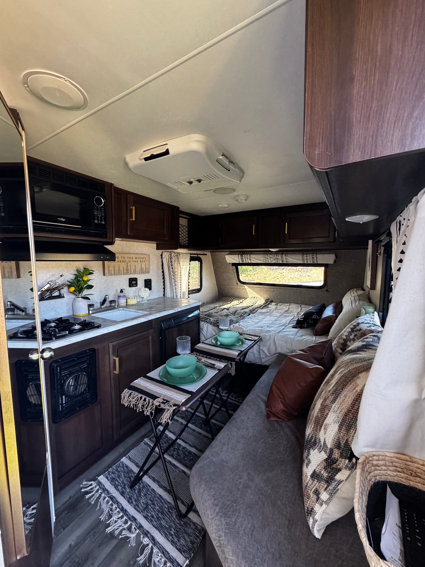 Inviting RV rental interior for glamping. Features a kitchen, dining area, bed, and cozy living space.