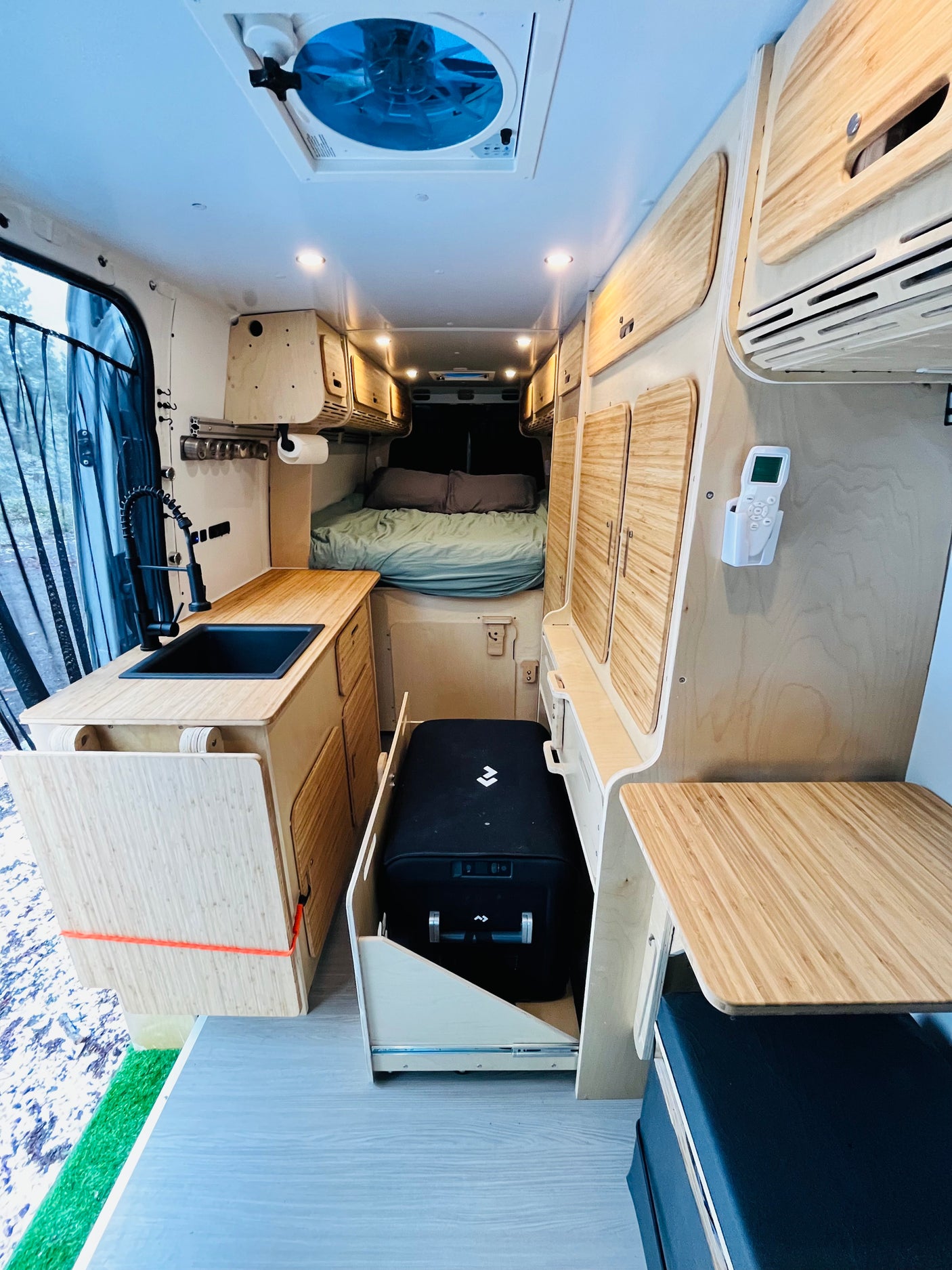 Step inside this RV rental! Features a compact kitchen with sink, comfy bed, and clever bamboo storage, ideal for van life adventures.