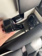 A hand connects a black seat belt buckle to its receiver in a modern RV rental interior, ensuring passenger safety.