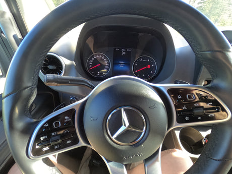 Driver's view in an rv rental: Mercedes-Benz steering wheel & dashboard showing 1295.6 miles, controls, and 71°F.