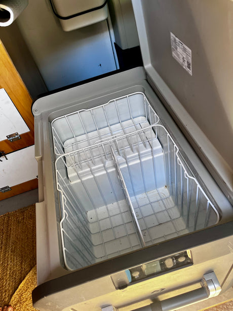 Open Dometic portable RV fridge/freezer with organized wire baskets, ideal for your next rv rental trip.