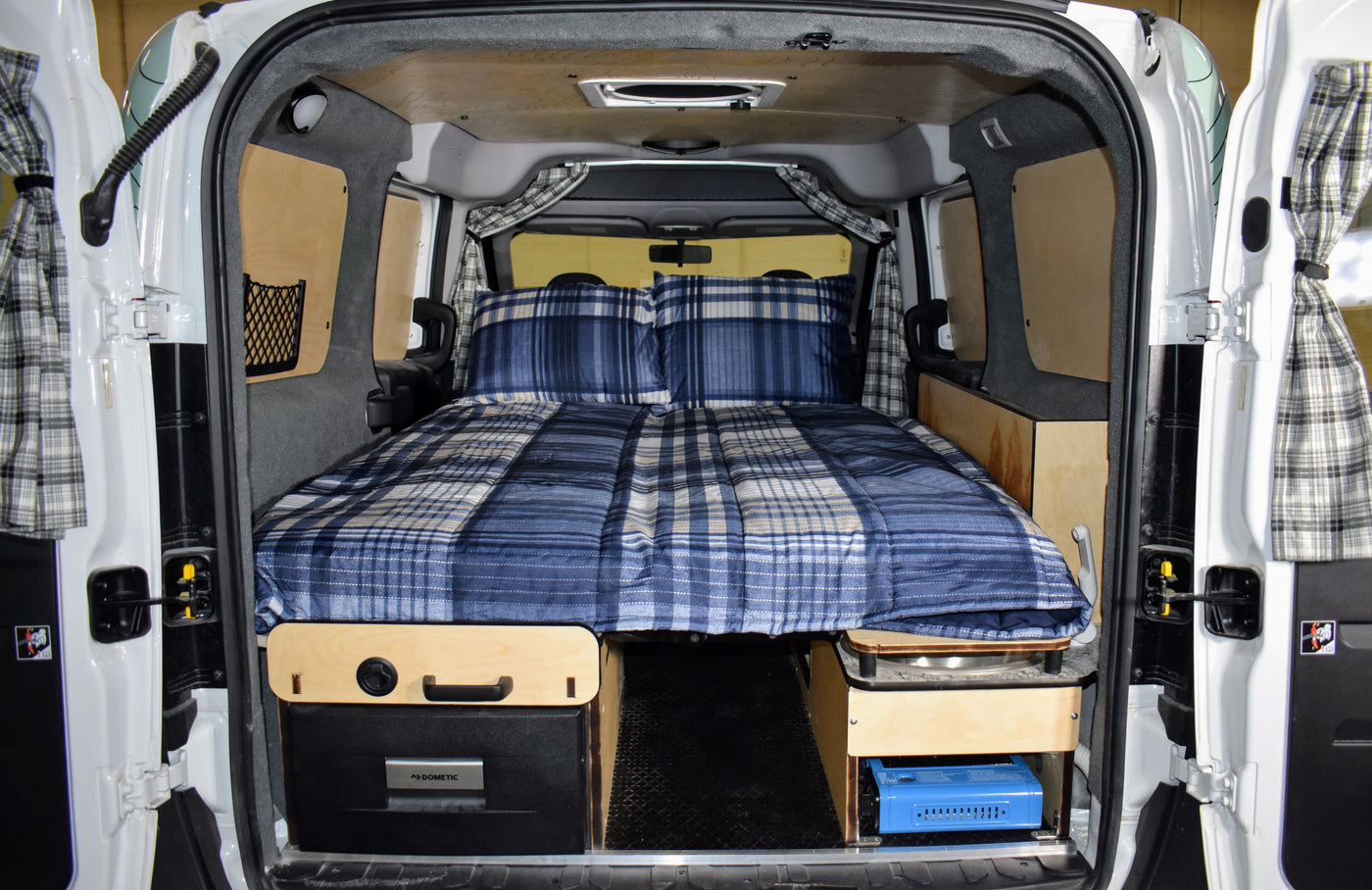 This RV rental offers a cozy bed, Dometic fridge, and portable stove, perfect for camping and mobile living. — photo 4