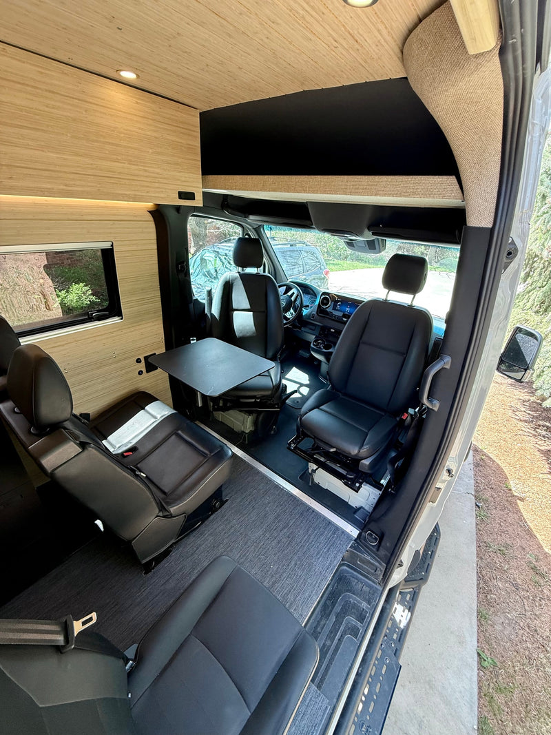 RV rental camper van interior: Swivel seats, dining table, and cozy wood paneling offer a comfy mobile living space. — photo 6