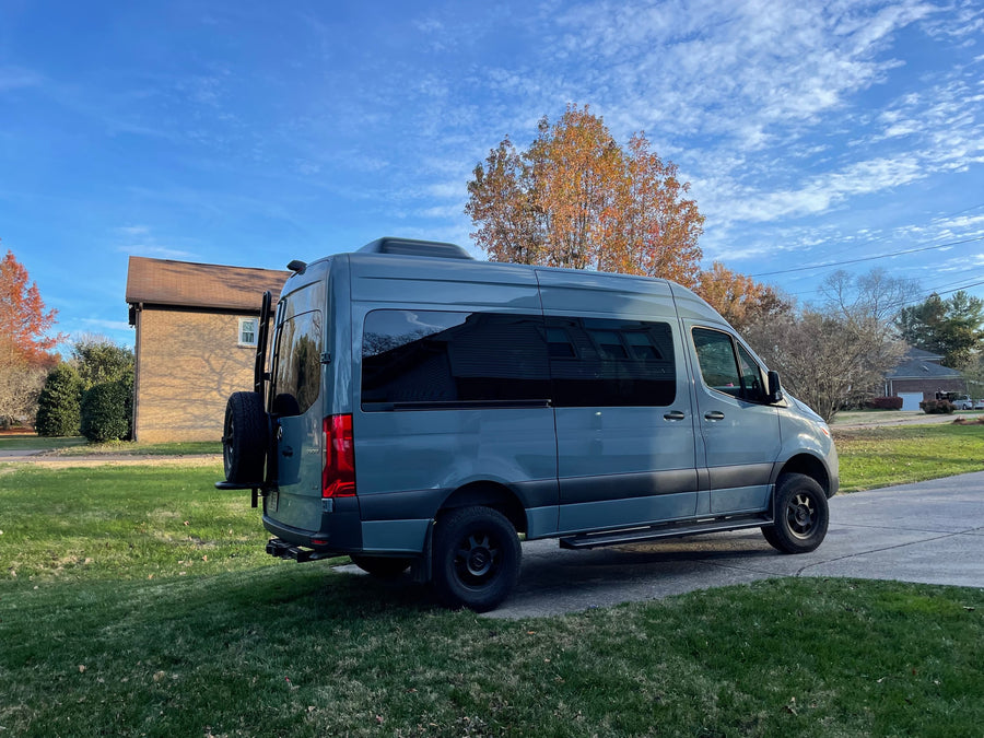  ideal for RV rental group trips. Features multiple rows of black seats and large windows.|A customized gray Mercedes-Benz Sprinter van