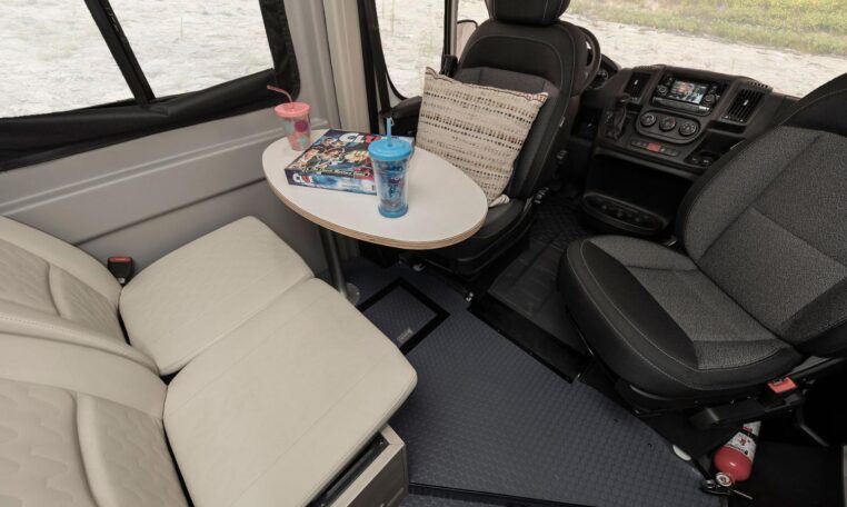 Cozy rv rental interior: dining table, swiveling seats, & board games for your next adventure. — photo 11