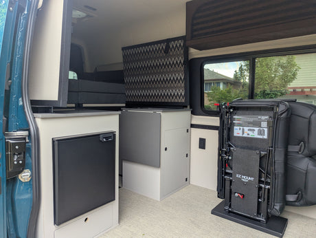 Explore this rv rental camper van interior: compact kitchenette with fridge, clever storage, and adaptable EZ Mount seating system.