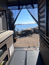 Experience adventure with an RV rental: view from inside looking out at a mountain bike by a lake.