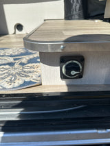 Power management on an rv rental: a Blue Sea battery switch set to 'OFF,' mounted on a wood-grain panel.