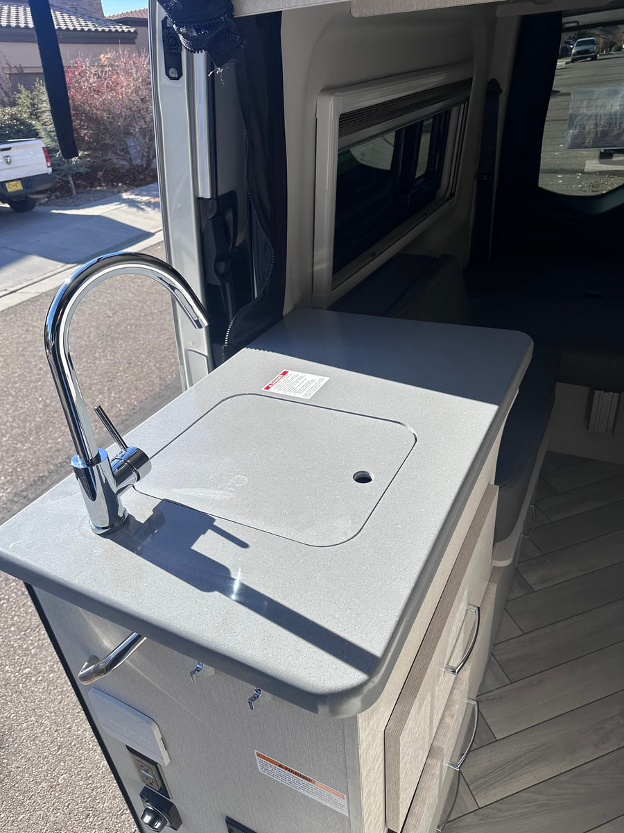  & digital dash.|RV rental's side door reveals a compact kitchen with a sink