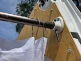 An RV rental's side panel features a mounted curtain rod with white privacy curtains, secured by hooks for outdoor use.