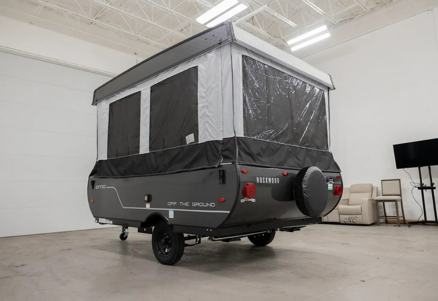 This gray Rockwood OTG pop-up camper rv rental is ready for adventure. Features canvas sides, clear windows, and a rear spare tire.