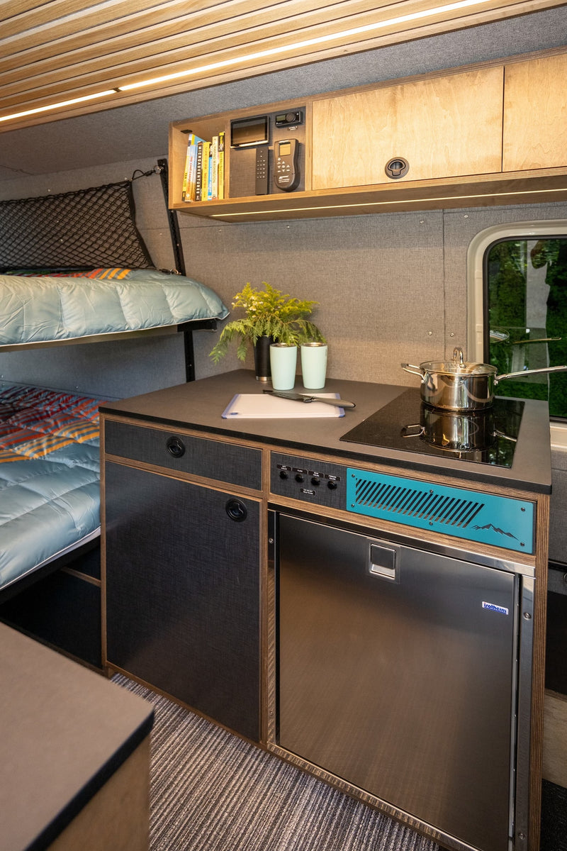Modern RV rental interior: compact kitchen with stove, fridge, and cozy bunk beds, all in a smartly designed space. — photo 9