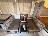 Pop-up RV rental interior: Dinette seating, a stowed table, portable stove, and tent walls with exit sign.