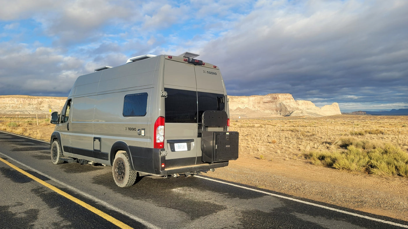 Adventure-ready RV rental van on a desert road trip with scenic rock formations under a cloudy sky. Perfect for van life. — photo 8
