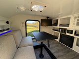 Cozy rv rental interior with dining area, fireplace, and window view for compact living.