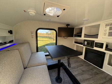 Cozy rv rental interior with dining area, fireplace, and window view for compact living.