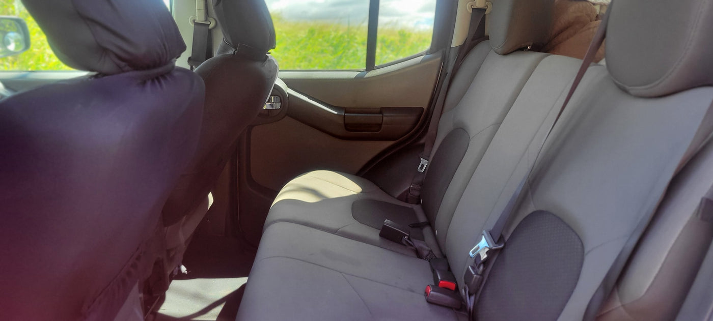 View inside a vehicle: gray rear seats, seatbelts visible. Green fields outside window. Perfect for a road trip, even an RV rental. — photo 20