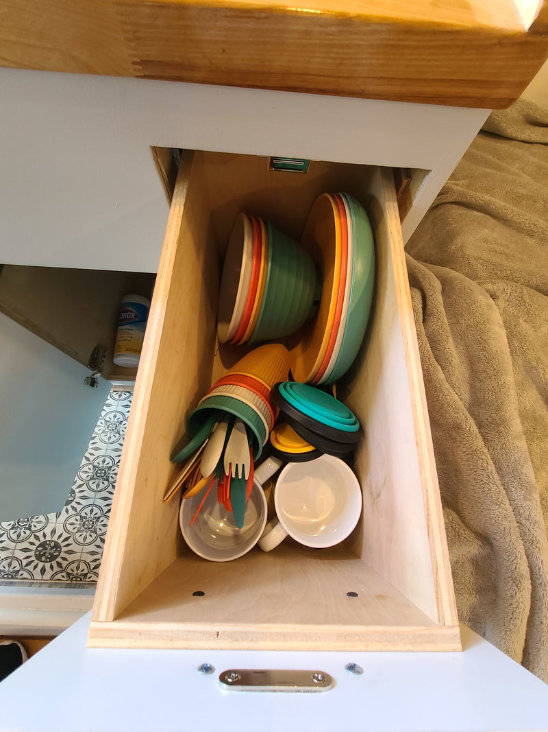 Inside an RV rental: a neat kitchen drawer with colorful bowls, cups, utensils, and collapsible items for compact living. — photo 14