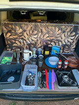 RV rental adventure ready! Organized camper kitchen with stove, pots, cutlery & coffee setup for your outdoor travels.