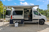 Silver Sprinter camper van rv rental with open doors, outdoor setup, and extended awning for adventure travel. Perfect for van life.