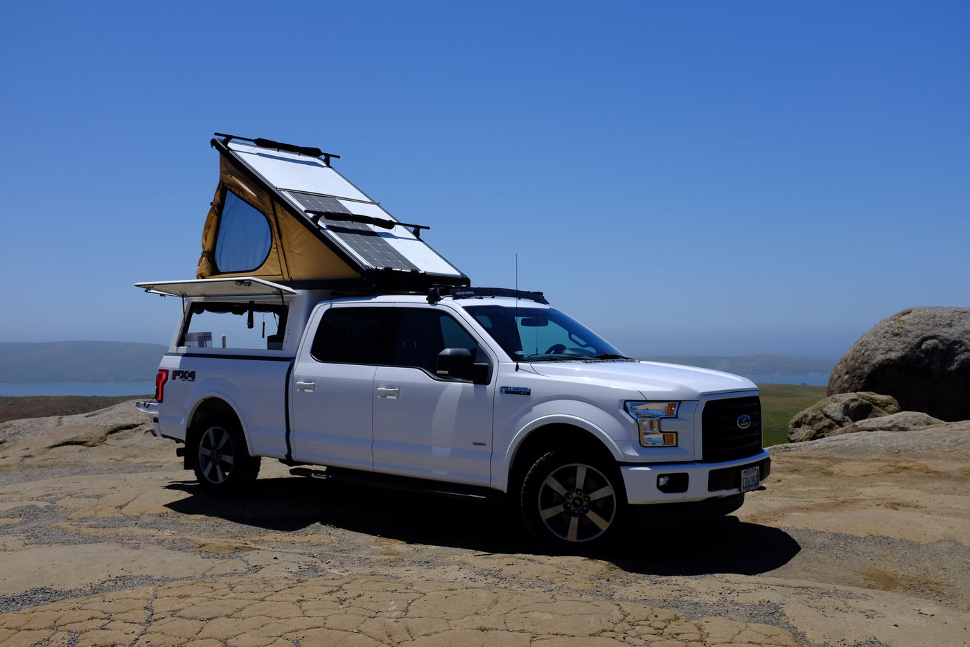 This white Ford F-150 pickup, equipped with a pop-up tent & solar panels, is an ideal RV rental for scenic coastal exploration. — photo 3